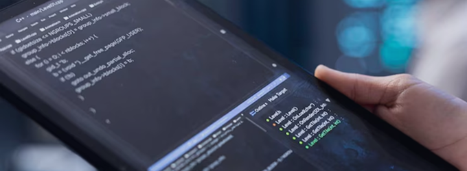 IT specialist reviewing backend application code and deployment targets on a tablet device