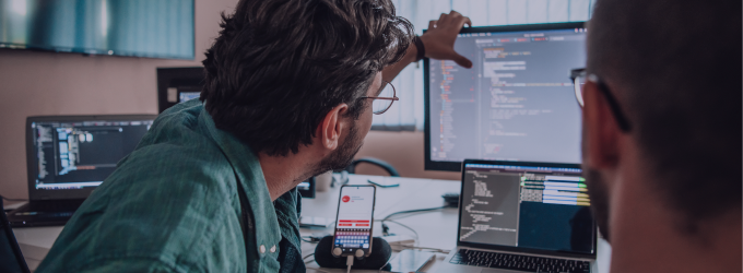 Ontwikkelaars die samenwerken en samen code beoordelen in een vergadering over een softwareproject