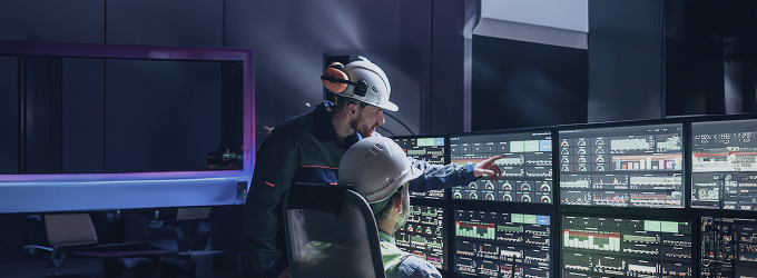 Operations team analyzes production metrics and machinery performance n a high-tech control center.