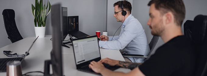 Innowise employees working on a digital product in a quiet office space with headphones and focus on screens