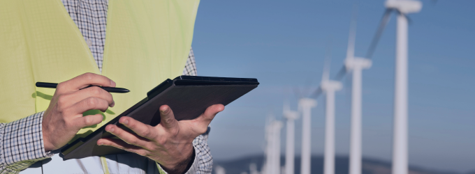 Wind energy specialist collects blade efficiency data using mobile diagnostics for power output optimization.