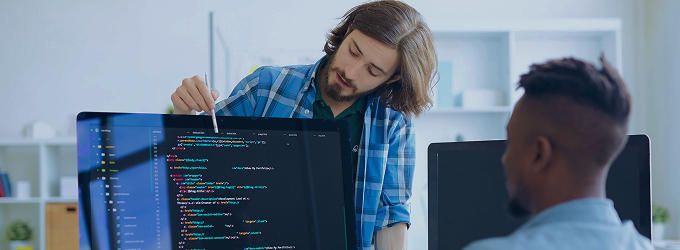 Software engineer explaining source code to a team member during a collaborative coding session