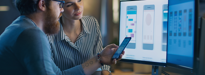 Discussione del team di progettazione sui prototipi di interfaccia utente, revisione dei progetti di app interattive su display digitali