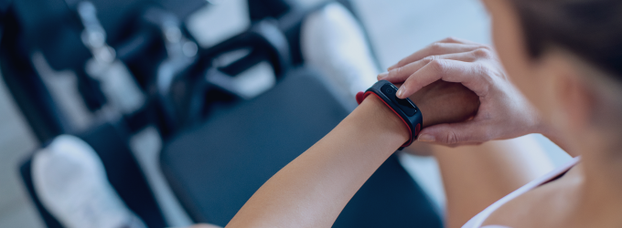 L'entraîneur personnel suit la fréquence cardiaque et l'intensité de l'entraînement de son client en temps réel grâce à un bracelet de fitness portable.