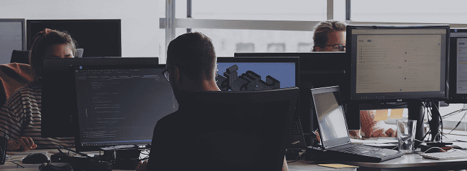 Development team focused on coding and 3D modeling in a modern tech office