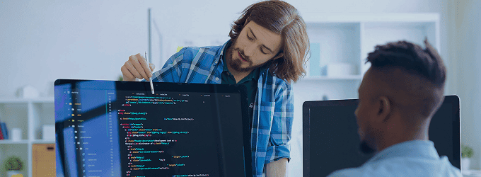 Software engineer explaining source code to a team member during a collaborative coding session