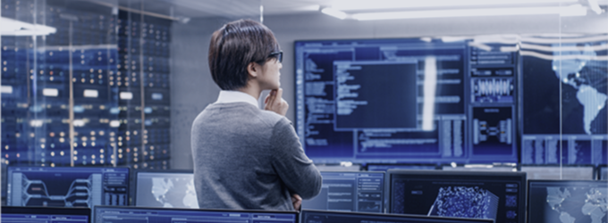 Analyst, der in einem Hightech-Betriebszentrum globale Daten und Netzaktivitäten in Echtzeit überprüft