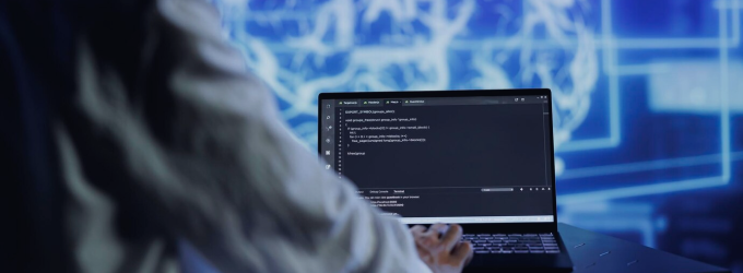 Inżynier oprogramowania przeglądający kod źródłowy na laptopie w środowisku opartym na technologii