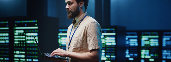 Engineer updating software and monitoring systems with a laptop in a technology workspace