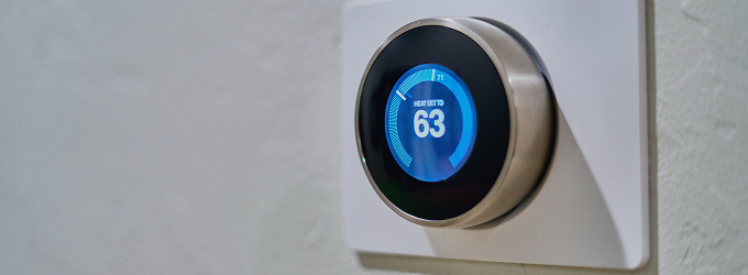 Il proprietario della casa monitora la temperatura interna tramite un termostato collegato per ottimizzare il controllo del clima.