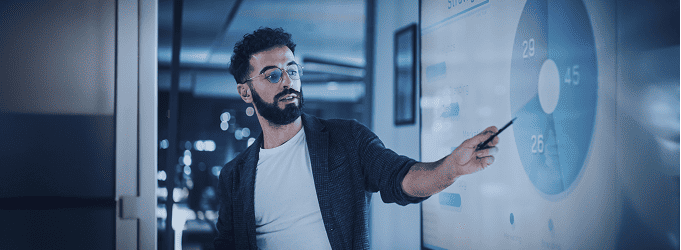 Business leader explains customer distribution metrics on a wall-mounted analytics dashboard