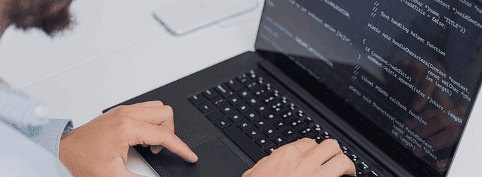 Developer writing and testing code on a laptop during software development in a modern workspace